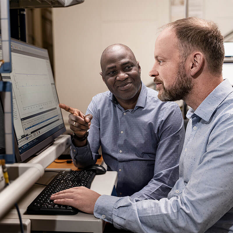 Two people looking at data on a computer screen
